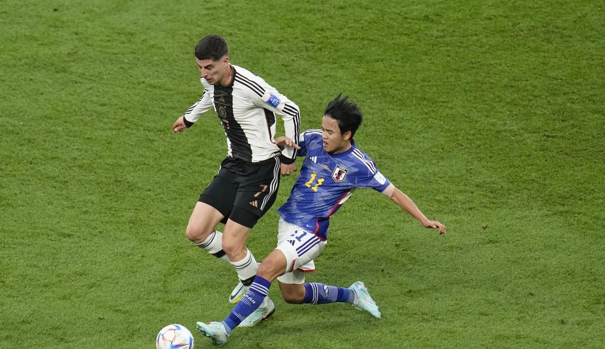 Penyerang Jerman, Kai Havertz berebut bola dengan gelandang Jepang, Takefusa Kubo selama pertandingan grup E Piala Dunia 2022 Qatar di Stadion Internasional Khalifa di Doha, Qatar, Rabu (23/11/2022). Dengan kemenangan ini, Jepang untuk sementara berada di puncak klasemen. (AP Photo/Ricardo Mazalan)