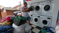 Imam Agus Kartawinata, memberikan layanan laundry gratis bagi warga Bandar Lampung yang terdampak banjir. Foto : (Istimewa).