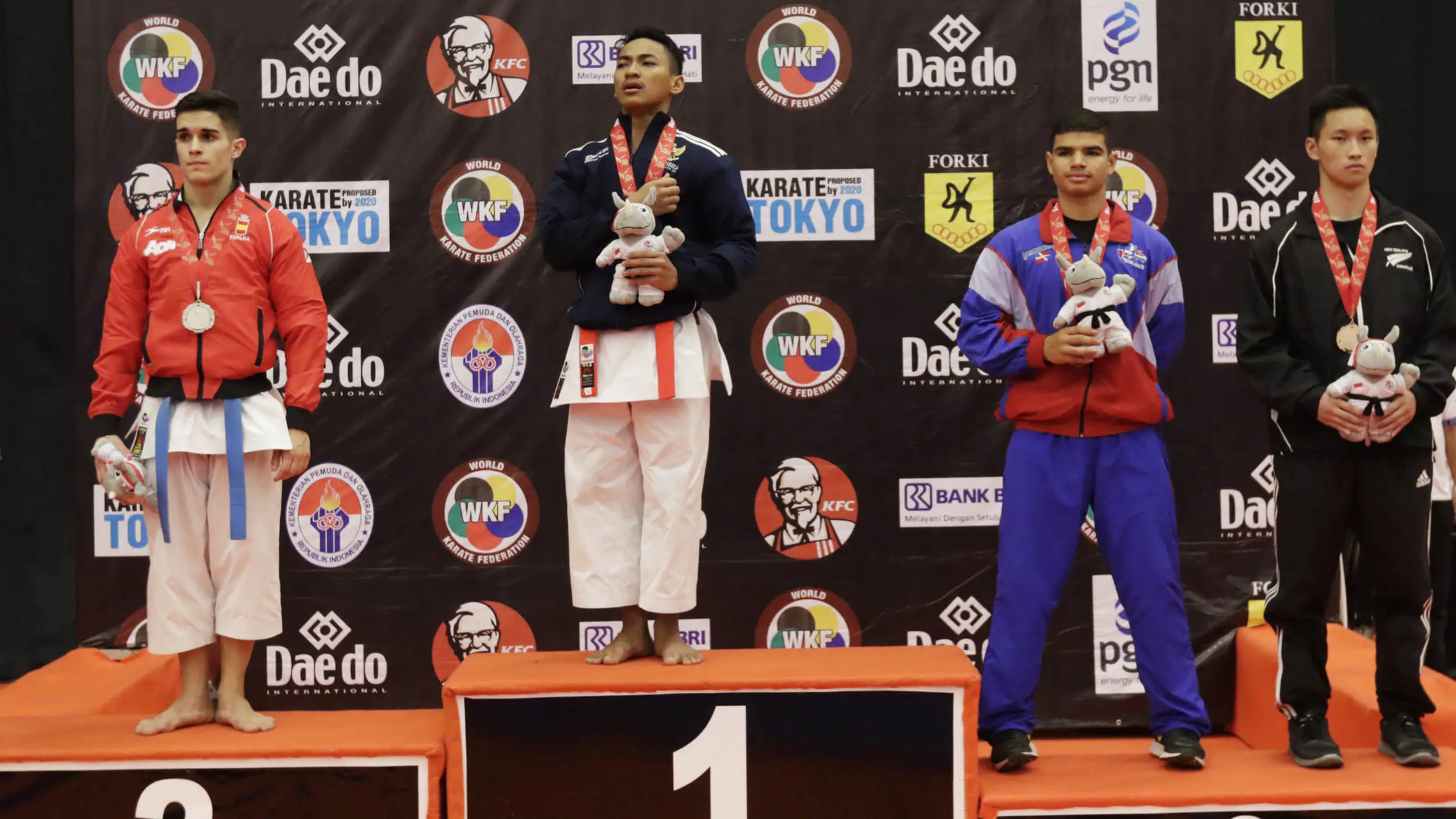 Karateka Indonesia, Ahmad Zigi Zaresta naik podium dan mengumandangkan Indonesia Raya usai meraih juara nomor Junior Kata pada Kejuaraan Dunia Karate Junior, Cadet dan U-21, di ICE, BSD, Tangerang, Kamis (12/11/2015). (Bola.com/Vitalis Yogi Trisna)