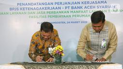 Direktur Utama BPJS Ketenagakerjaan (BPJAMSOSTEK) Anggoro Eko Cahyo (kanan) dan Direktur Utama Bank Aceh Haizir Sulaiman (kiri) saat menandatangani PKS terkait Penyediaan Layanan dan Jasa Perbankan dalam Rangka Pemberian MLT di Jakarta, Kamis (24/03/2022). (Liputan6.com/Fery Pradolo)