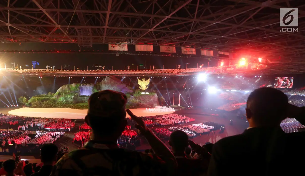 Penonton memberi hormat saat pengibaran bendera Merah Putih dalam pembukaan Asian Games 2018 di Stadion Utama Gelora Bung Karno (SUGBK), Jakarta, Sabtu (18/8). Acara pengibaran bendera berlangsung khidmat. (Liputan.com/Fery Pradolo)