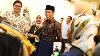 Presiden Joko Widodo atau Jokowi didampingi Menteri Perindustrian Airlangga Hartarto melihat-lihat busana saat menghadiri pembukaan Muslim Fashion Festival (Muffest) Indonesia Tahun 2018 di JCC, Kamis (19/4). (Liputan6.com/Immanuel Antonius)