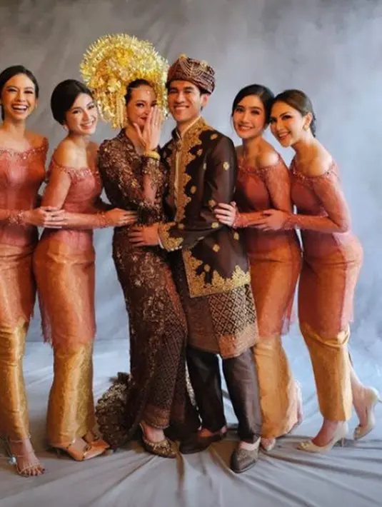 Mereka kenakan kebaya boatneck berwarna kemerahan dan kain tenun emas [@yukikt]