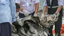 Petugas KNKT memeriksa bagian turbin pesawat Sriwijaya Air dihari kelima yang jatuh di perairan Pulau Seribu, di Dermaga JICT, Jakarta,  Rabu (13/1/2021). Pengangkatan mesin turbin pesawat Sriwijaya Air SJ 182 itu menggunakan crane milik KRI Cucut 866. (Liputan6.com/Faizal Fanani)