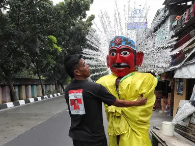 Pemilik tengah memperbaiki ondel-ondel untuk disewakan di kawasan Senen, Jakarta, Jumat (20/9/2024). (Liputan6.com/Angga Yuniar)
