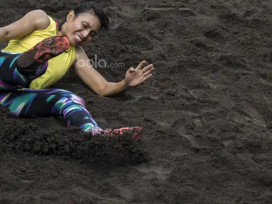 Atlet atletik Indonesia, Maria Londa, melakukan pendaratan saat latihan jelang SEA Games 2017 di Lapangan umum Mengwi, Bali, Minggu (10/7/2017). (Bola.com/Vitalis Yogi Trisna)