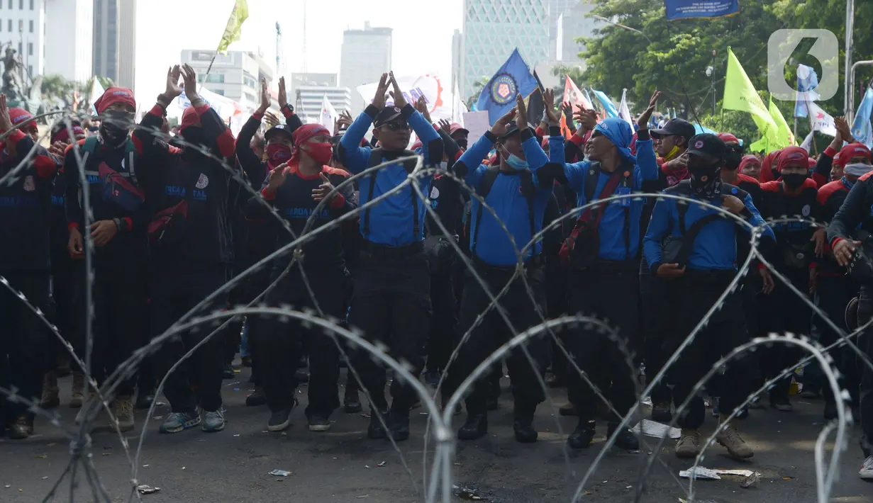 Pengunjuk rasa dari berbagai elemen buruh berunjuk rasa di kawasan Patung Kuda, Jakarta, Rabu (8/12/2021). Dalam aksinya tersebut mereka meminta pemerintah dan DPR mencabut Undang-undang Nomor 11 Tahun 2020 tentang Cipta Kerja. (merdeka.com/Imam Buhori)