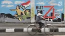 Pesepeda melintas di depan mural bertema Kemerdekaan Indonesia yang dibuat PPSU Kelurahan Pondok Bambu di Jalan Kolonel Sugiono, Jakarta, Selasa (13/8/2019). Mural dalam rangka menyambut Hari Kemerdekaan pada 17 Agustus itu sekaligus mempercantik jalanan Ibu Kota. (merdeka.com/Iqbal S Nugroho)