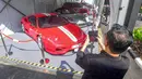 Pengunjung memfoto mobil mewah yang siap dilelang terbuka pada acara Badan Pemulihan Aset (BPA) Kejaksaan Agung Fair 2026 di Jakarta, Kamis (21/5/2026). (merdeka.com/Arie Basuki)