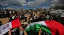 Warga Palestina membawa jenazah warga Palestina yang tewas dalam serangan Israel selama perang dengan Hamas setelah ditemukan dari bawah reruntuhan bangunan, dalam prosesi pemakaman di Kota Gaza, Kamis (1/10/2026). Jenazah yang dibungkus bendera Palestina tersebut diusung oleh para pelayat menuju lokasi pemakaman. Keluarga dan warga setempat turut mengiringi prosesi dalam suasana duka untuk memberikan penghormatan terakhir kepada para korban. (AP Photo/Yousef Al Zanoun)