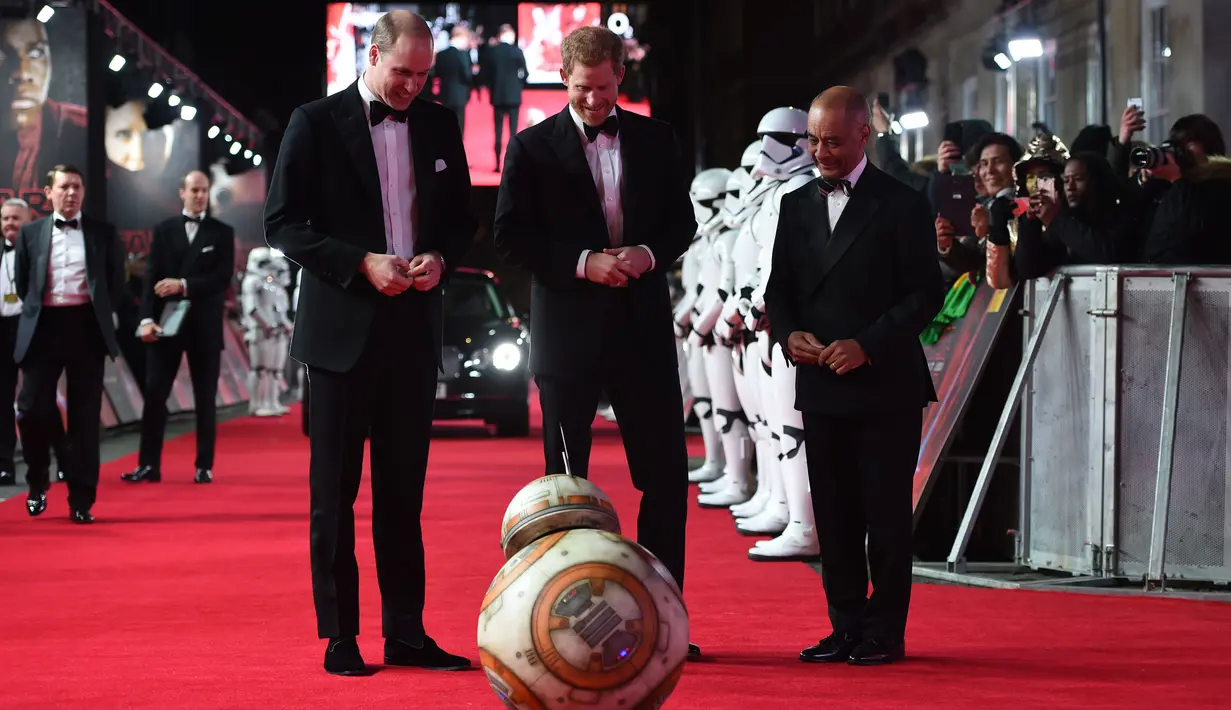 Pangeran William dan Pangeran Harry melihat robot droid BB-8 ketika berjalan di karpet merah premiere film The Star Wars: The Last Jedi yang digelar di The Royal Albert Hall, London, Inggris, Selasa (12/12). (Eddie Mulholland/Pool Photo via AP)