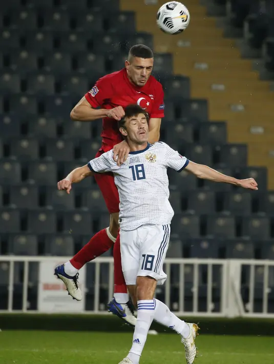 Bek Turki, Merih Demiral berebut bola dengan pemain Rusia, Yuri Zhirkov pada pertandingan UEFA Nations League di Stadion Sukru Saracoglu, Istanbul, Minggu (15/11/2020). Turki menang tipis atas Rusia 3-2. (AP Photo)