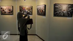 Penunjung melihat pameran foto yang dipamerkan dalam pameran foto Warna-Warni Parlemen di Kompleks Parlemen, Senayan, Jakarta, Senin (29/8). (Liputan6.com/JohanTallo)