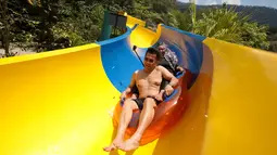 Pengunjung menggunakan pelampung meluncur di perosotan air terpanjang di dunia di Escape theme park di Teluk Bahang, Malaysia (25/9/2019). Perosotan ini mengalahkan perosoton terpanjang yang berada di New Jersey dengan panjang 605m. (AFP Photo/Sadiq Asyraf)