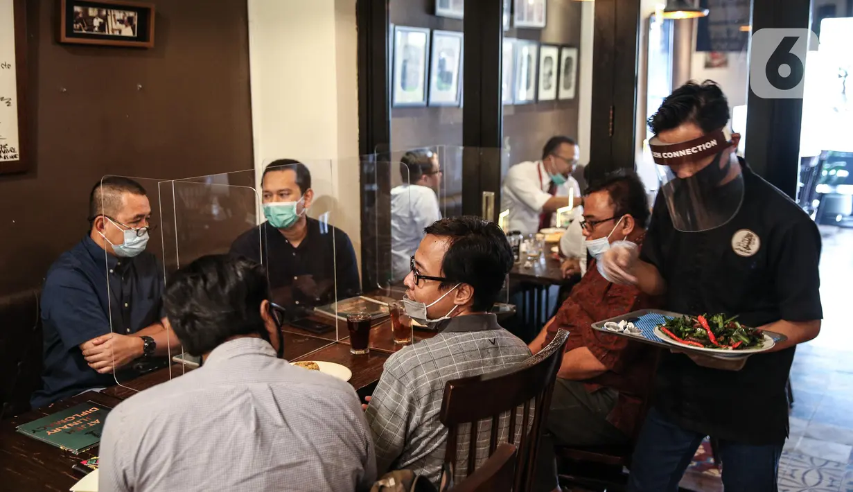 Pramusaji menggunakan pelindung wajah, masker dan sarung tangan saat melayani pelanggan di The Atjeh Connection Coffee and Resto, Jakarta, Senin (8/6/2020). Tempat ini siap menerapkan protokol kesehatan dalam menerapkan tatanan kehidupan baru atau ‘new normal’. (Liputan6.com/Faizal Fanani)