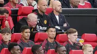 Ekpresi ngenyek pemain Manchester United, Cristiano Ronaldo, saat berada di bangku cadangan kala MU tertinggal dua gol dari Brighton and Hove Albion pada laga Liga Inggris di Stadion Old Trafford, Minggu (07/08/2022). (Ian Hodgson/PA via AP)