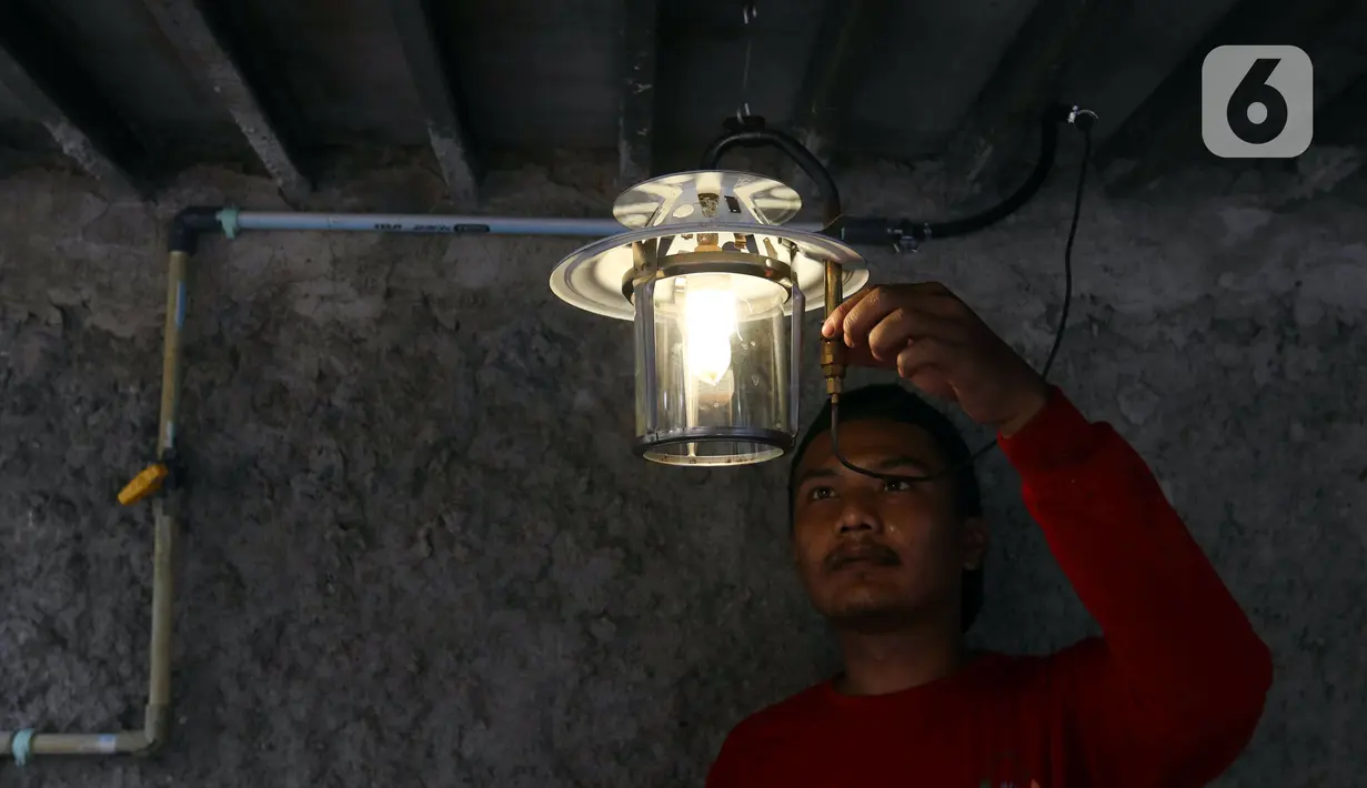 <p>Pekerja menyalakan lampu menggunakan bahan bakar biogas yang mengubah kotoran sapi menjadi gas untuk kebutuhan tumah tangga di kawasan Pancoran, Jakarta, Selasa (12/12/2023). (Liputan6.com/Herman Zakharia)</p>