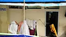 Dua orang pedagang wanita terlihat tengah bersiap untuk sholat di depan toilet umum di Pasar Blok G, Tanah Abang, Jakarta, (8/7/2014). Mereka beralasan karena lebih dekat dengan lokasi mereka berjualan (Liputan6.com/ Faizal Fanani)