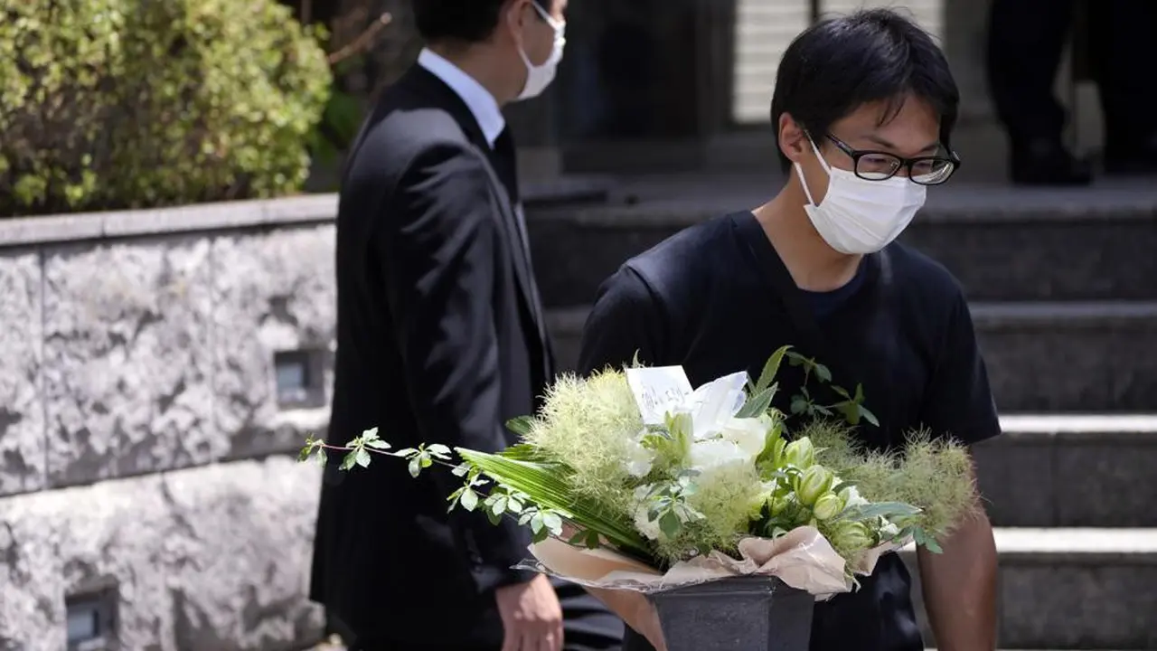 Seorang perwakilan toko bunga membawa bunga belasungkawa di kediaman mantan Perdana Menteri Jepang Shinzo Abe di Tokyo. (Foto AP/Eugene Hoshiko)