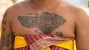 Sebuah tato berbentuk Pulau Bali terlihat di dada seorang pria saat berlangsungnya ritual Hindu Bali bernama Usaba Sri di Karangasem, Bali, Senin, 10 Agustus 2026. (Foto AP/Firdia Lisnawati)