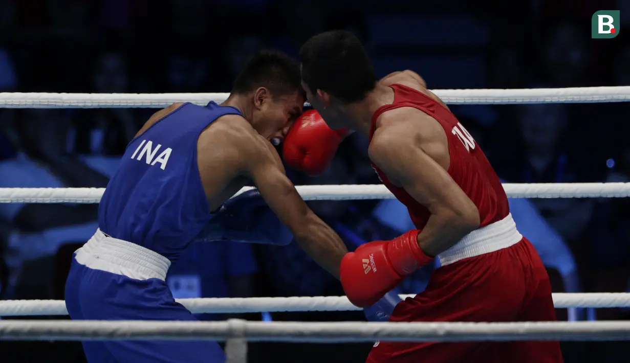 Petinju Indonesia, Farrand Papendang, beradu pukul dengan petinju Thailand, Khunatip Pidnuch, pada semifinal kelas 60 kg SEA Games 2019 di PICC Forum, Manila, Minggu (8/12). Farrand kalah dengan poin 139-146. (Bola.com/M Iqbal Ichsan)