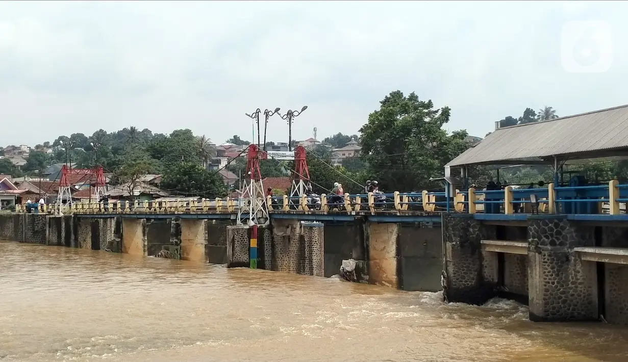 Sejumlah pengendara melintasi Bendung Katulampa, Bogor, Jawa Barat, Senin (10/10/2022). Setelah sebelumnya tinggi muka air (TMA) mencapai 220 Cm dengan status Siaga 1, pada pukul 13.23 WIB Bendung Katulampa terpantau kembali pada status normal. (Liputan.com/Magang/Aida Nuralifa)