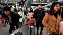 Calon penumpang membawa barang bawaan saat akan naik kereta di sebuah stasiun di Fuyang, Provinsi Anhui, China, Minggu (10/2). Pulang ke kampung halaman menjadi tradisi warga China saat Tahun Baru Imlek. (Chinatopix via AP)