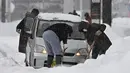 Orang-orang menyekop salju di sekitar mobil yang terjebak di salju di Toyama, di pesisir Laut Jepang, Senin (11/1/2021). Sekitar 1000 kendaraan terjebak di jalan raya bersalju di kota Sakai pada pagi hari, sementara 200 mobil lainnya terdampar di jalan raya di tengah salju tebal di kota Nanto. (Kyod