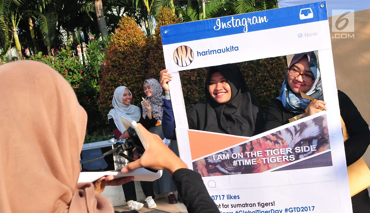 Warga berfoto menggunakan atribut dari forum harimaukita saat kampanye Global Tiger Day di Bundaran HI, Jakarta, Minggu (30/7). Acara ini untuk memperingati Tiger Day yang jatuh setiap tgl 29 Juli. (Liputan6.com/Helmi Afandi)