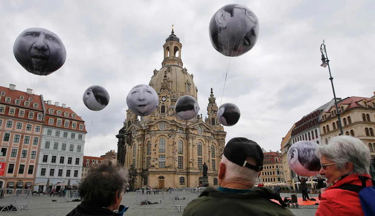 Warga melihat balon bergambar muka para pemimpin negara G7 yang dibuat oleh kelompok ONE, Dresden, Jerman, (27/5/2015). Dresden menjadi tuan rumah pertemuan menteri keuangan dan gubernur bank sentral G7. (REUTERS/Fabrizio Bensch)