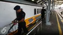 Dua personil brimob mengawal rangkaian gerbong  Kerata Api di Stasiun Tugu, Yogyakarta, Selasa (28/6). Perbaikan di lakukan untuk memperlancar arus mudik dengan menggunakan transportasi layanan kereta api. (Liputan6.com/Boy Harjanto)
