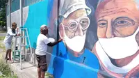 Foto :Para pelukis jalanan di Kota Maumere, NTT sedang melukis di dinding tembok sebagai pesan moral melawan covid-19 (Liputan6.com/Dion)