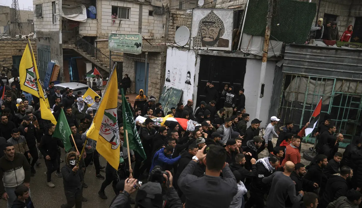 Para pelayat Palestina membawa jenazah Mufid Khalil selama pemakamannya di desa Beit Ummar, Tepi Barat, dekat Hebron (29/11/2022). Kementerian Kesehatan Palestina mengatakan, Khalil terbunuh oleh tembakan Israel di Tepi Barat yang diduduki.  (AP Photo/Mahmoud Illean)