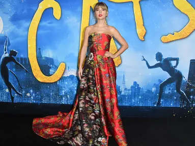 Penyanyi AS Taylor Swift berpose saat tiba menghadiri pemutaran perdana film "Cats" di Alice Tully Hall di New York City (16/12/2019). Taylor Swift  tampil anggun mengenakan gaun bunga merah dengan lipstik merah dibibirnya. (AFP/Angela Weiss)