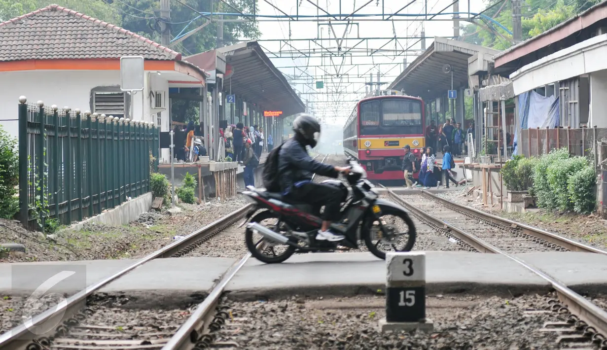 Pengendara motor melintasi palang pintu kereta di pintu pelintasan Kalibata, Jakarta, (4/12). Untuk menekan angka kecelakaan, Pemprov DKI Jakarta berencana membangun flyover diperlintasan kereta api. (Liputan6.com/Yoppy Renato)