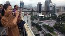 Menteri BUMN, Rini Soemarno mengabadikan gambar demo 2 Desember di atas gedung BUMN, Jakarta, Rabu (2/12). Demo 2 Desember digelar sebagai lanjutan dari aksi 4 November 2016. (Liputan6.com/Ferbian Pradolo)