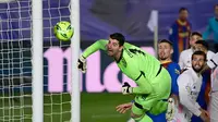 Kiper Real Madrid, Thibaut Courtois menatap bola yang masih melebar dari gawangnya saat melawan Barcelona dalam laga lanjutan Liga Spanyol 2020/2021 pekan ke-30 di Alfredo di Stefano Stadium, Madrid, Sabtu (10/4/2021). Real Madrid menang 2-1 atas Barcelona. (AFP/Javier Soriano)