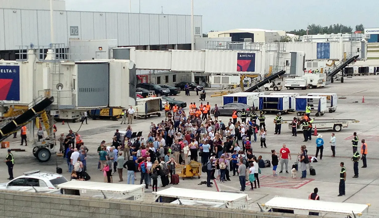 Penumpang dievakuasi di landasan pesawat saat penembakan di Bandara Fort Lauderdale, Florida, AS (6/1). Peristiwa penembakan terjadi di tempat pengambilan bagasi bandara di Terminal 2. (AP Photo/Wilfredo Lee)