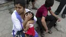 Seorang ibu tampak memeluk anaknya saat gempa susulan kembali melanda Nepal, Selasa (12/5/2015). Berdasarkan media setempat, kekuatan gempa mencapai 7,3 SR dan berlangsung lebih dari semenit. (REUTERS/Athit Perawongmetha)
