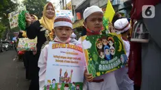 Sejumlah murid TK Islam berjalan bersama sambil membawa poster di Jalan Raya Radjiman Widyo Ningrat, Jakarta, Sabtu (26/3/2022). Pawai menyambut datangnya bulan suci Ramadan 1443 Hijriah ini diikuti puluhan murid TK Islam dari berbagai sekolah. (merdeka.com/Imam Buhori)