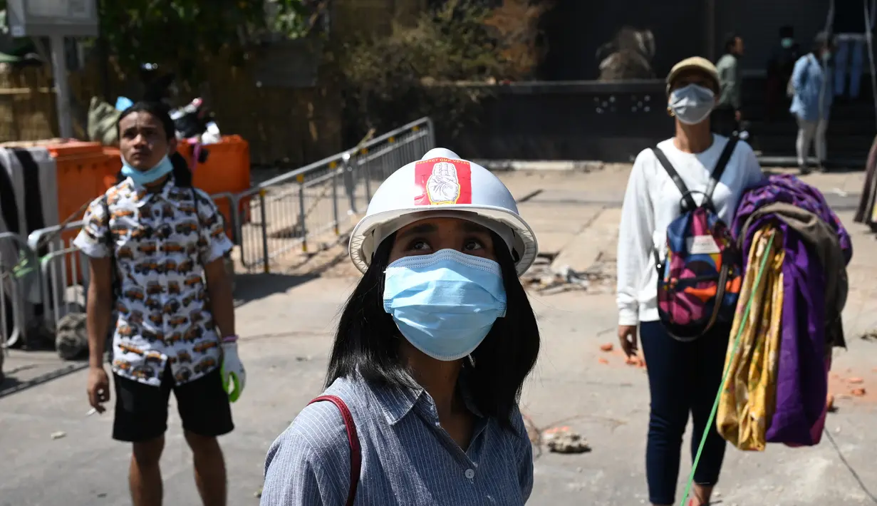 Pengunjuk rasa menggantung pakaian tradisional Myanmar bernama longyi di seberang jalan selama demonstrasi menentang kudeta militer di Yangon, Senin (8/3/2021). Para pengunjuk rasa membentangkan jemuran kain yang biasa dipakai perempuan untuk memperlambat gerak polisi dan tentara. (STR/AFP)