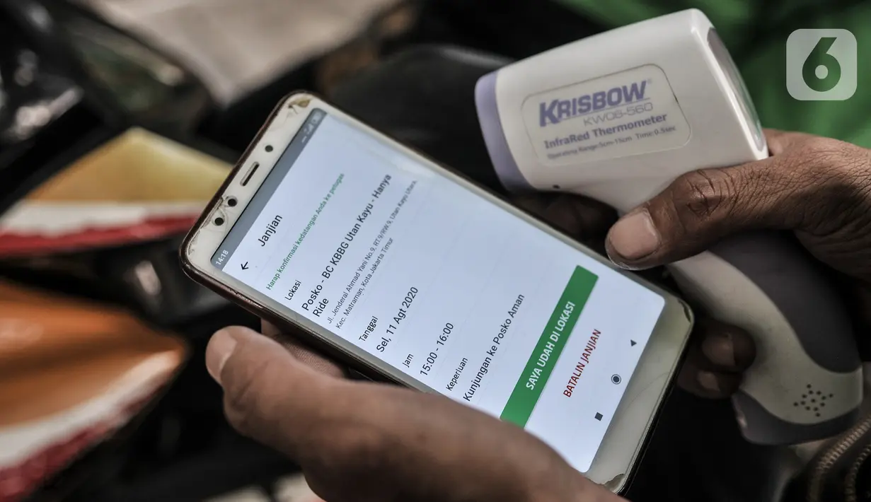 Petugas memeriksa data pengojek daring melalui aplikasi sebelum pemeriksaan rutin di Posko Aman Covid-19, Jakarta, Selasa (11/8/2020). Posko Aman Covid-19 rutin digelar untuk memeriksa kesehatan ojol guna mencegah penyebaran corona selama beroperasi di masa pandemi. (merdeka.com/Iqbal Nugroho)