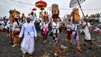 Umat Hindu berjalan untuk berdoa sambil membawa persembahan saat upacara Melasti di sebuah pantai di Denpasar, Bali, pada Rabu 26 Maret 2025. (Sonny TUMBELAKA/AFP)