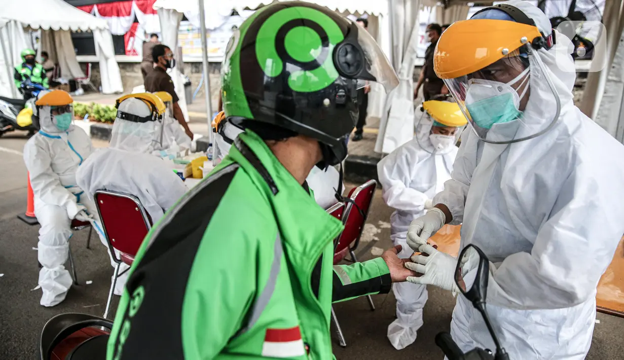 Pengemudi ojol mengikuti tes diagnostik cepat (rapid test) di depan gedung Kejaksaan Agung, Jakarta, Kamis (6/8/2020). Kejagung menggelar rapid test massal kepada warga yang melintas di kawasan itu guna memastikan kesehatannya dan mengantisipasi penyebaran COVID-19. (Liputan6.com/Faizal Fanani)