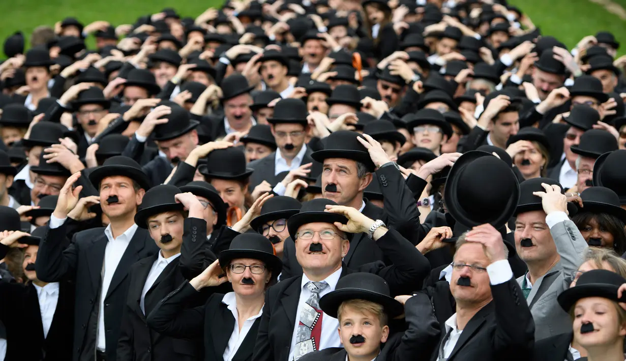 Ratusan penggemar berpakaian mirip Charlie Chaplin menggelar pertemuan di Corsier sur Vevey, Swiss, Minggu (16/4). Pertemuan yang dihadiri 662 orang itu memperingati hari jadi pertama Museum Charlie Chaplin di Swiss. (Laurent Gillieron/Keystone via AP)