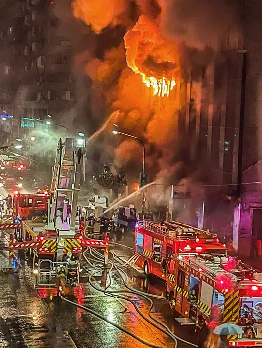 Petugas pemadam kebakaran memadamkan api di sebuah gedung di Kaohsiung, Taiwan selatan, Kamis (14/10/2021). Pemadam kebakaran mengatakan kepada BBC bahwa 79 orang telah dibawa ke rumah sakit, termasuk 14 di antaranya dalam kondisi serius. (EBC via AP )