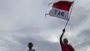Seorang suporter mengibarkan bendera merah putih saat mendukung Timnas Indonesia yang akan bertanding melawan Vietnam di Stadion Pakansari, Jawa Barat, Sabtu (3/12/2016). (Bola.com/Vitalis Yogi Trisna)