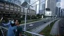Warga berkumpul diatas JPO tanpa atap di Jakarta, Minggu (12/9/2021). Kasus baru positif Covid-19 di Indonesia per Minggu (12/9) bertambah sebanyak 3.779 kasus Jumlah tersebut membuat total kasus virus corona sejak awal pandemi mencapai 4.167.511 kasus. (Liputan6.com/Faizal Fanani)