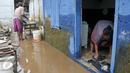 Warga mebersihkan sisa-sisa endapan lumpur di rumahnya, Cawang, Jakarta, Senin (7/11). Sebelumnya, ratusan rumah warga di RW 02 Cawang, Kramat Jati, Jakarta Timur tergenang akibat banjir kiriman dari kawasan Bogor. (Liputan6.com/Yoppy Renato)