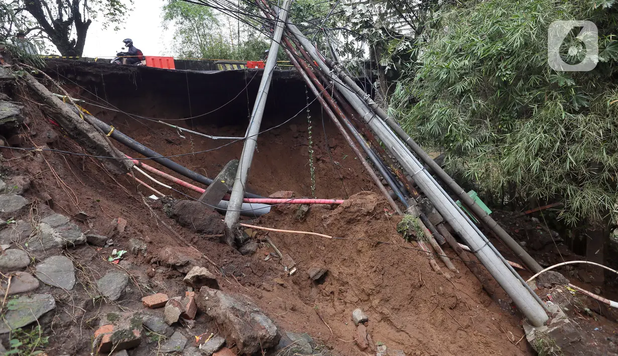 Kondisi longsor di kawasan Jembatan Darul Qur’an, Jalan KH. Tb. M. Falak, Kecamatan Bogor Barat, Kota Bogor, Jawa Barat, Rabu (12/10/2022). Longsor yang terjadi pada kemarin sore saat hujan deras menyebabkan jalan utama yang menghubungkan Jalan Semeru dengan Jalan Raya Loji-Gunung Batu kini hanya dapat dilalui sepeda motor. (merdeka.com/Arie Basuki)